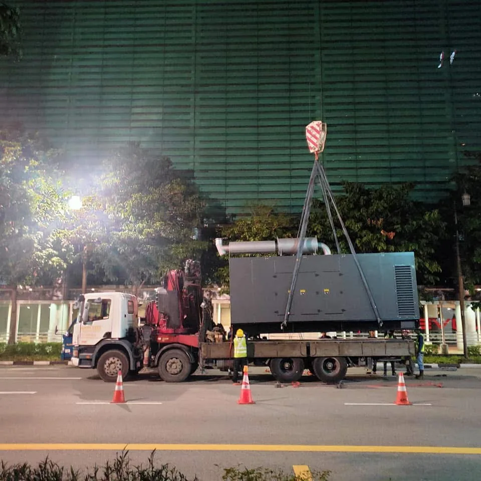 Lorry crane lifting generator equipment at night