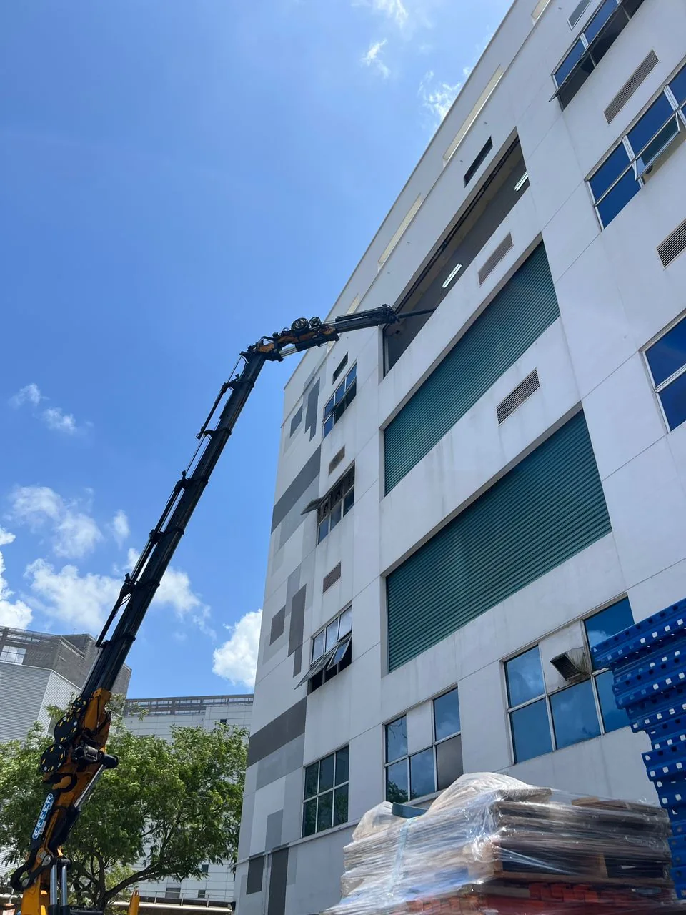 Lorry crane reaching upper floor opening