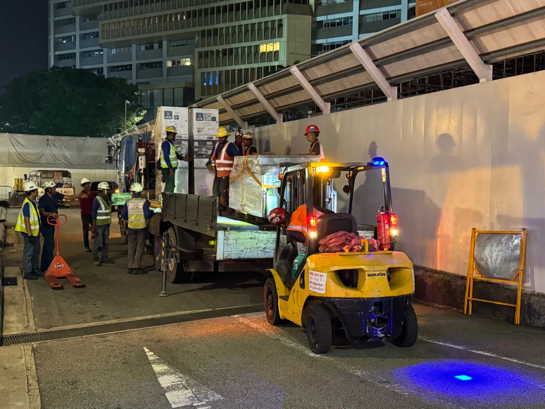 Forklift and lorry supporting machinery collection at night